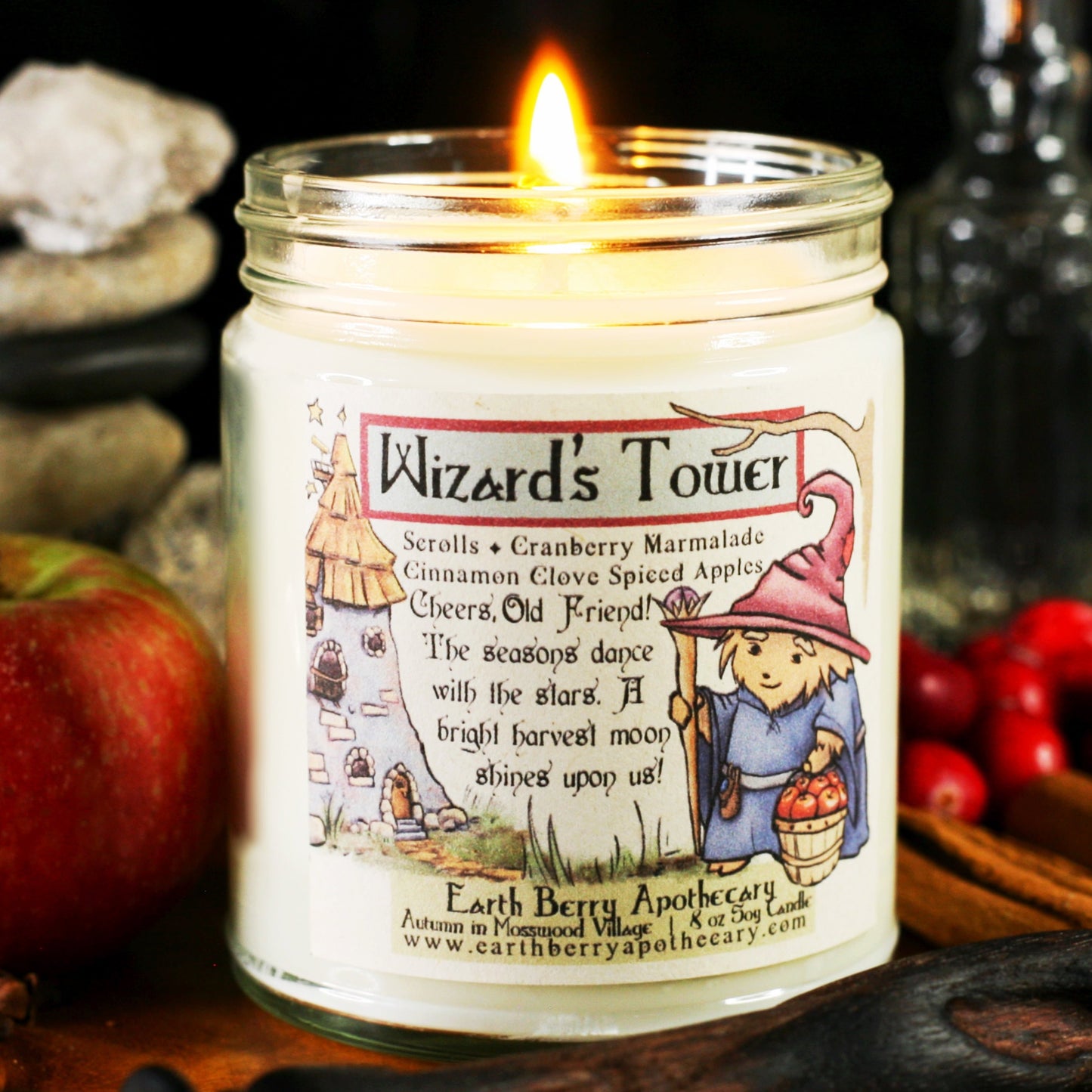 Wizards Tower soy candle with a stone tower and smiling hedgehog wizard holding a magic staff and a bucket of apples