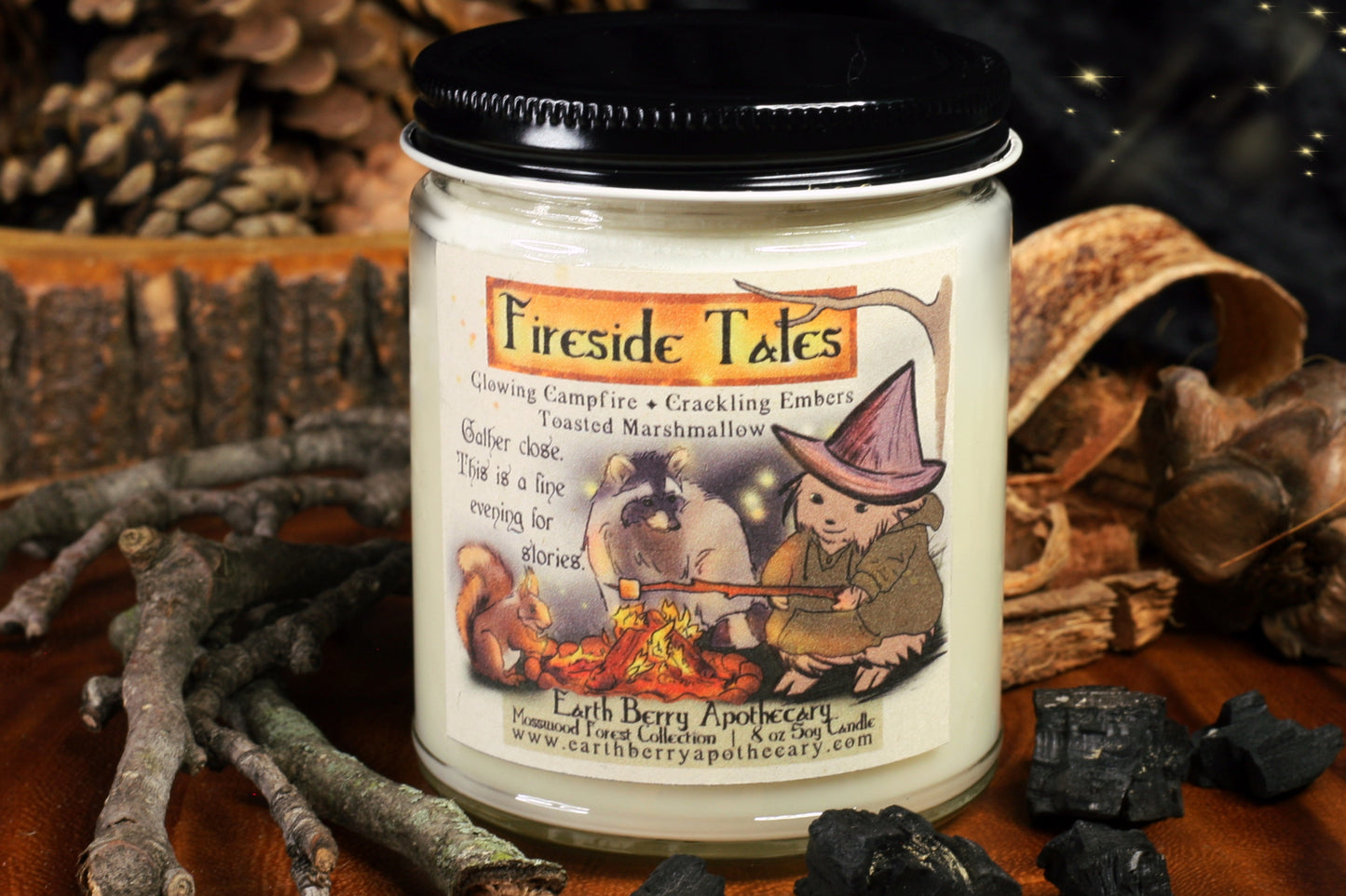 Fireside tales soy candle scented with campfire embers and toasted marshmallows. The hedgewitch sits in front of a campfire, tossing a marshmallow, while a raccoon and squirrel tell stories.