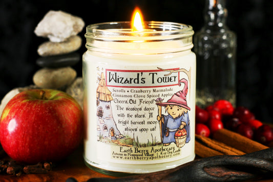 Wizards Tower soy candle with a stone tower and smiling hedgehog wizard holding a magic staff and a bucket of apples