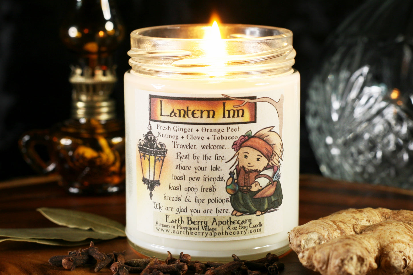 Lantern inn candle has a glowing old lantern and a hedgehog carrying a basket filled with vegetables, and a magical flask in the other hand. The scent is ginger, orange peel, clove, nutmeg, and tobacco
