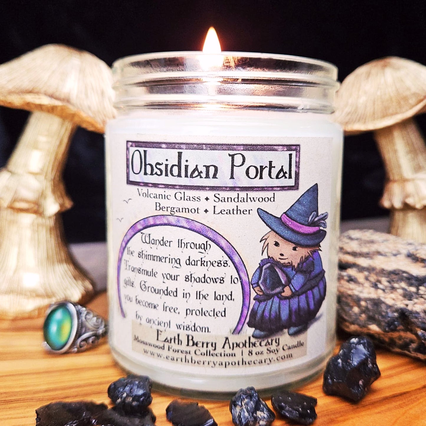 Lit candle labeled 'Obsidian Portal' with a cartoon hedgehog wearing a witch hat and clothes surrounded by crystals
