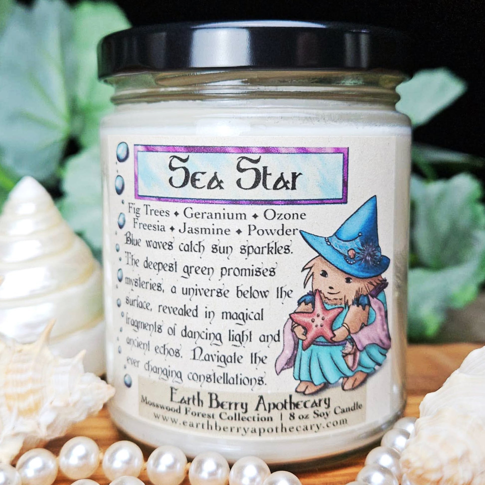 Candle jar labeled 'Sea Star' with a hedgehog witch and starfish design, surrounded by pearls and shells.