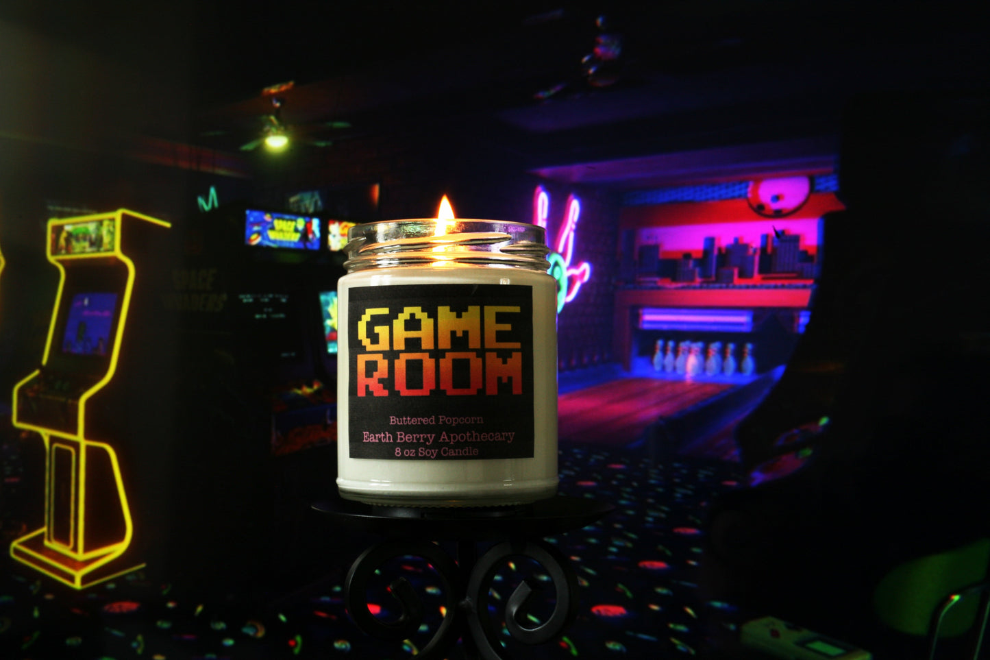 game room candle in front of arcade machines